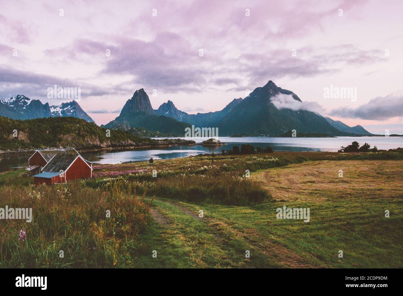 Norvegia paesaggio tramonto montagne sopra fiordo e case villaggio in Lofoten isole rurali scandinavia natura viaggio belle destinazioni paese Foto Stock
