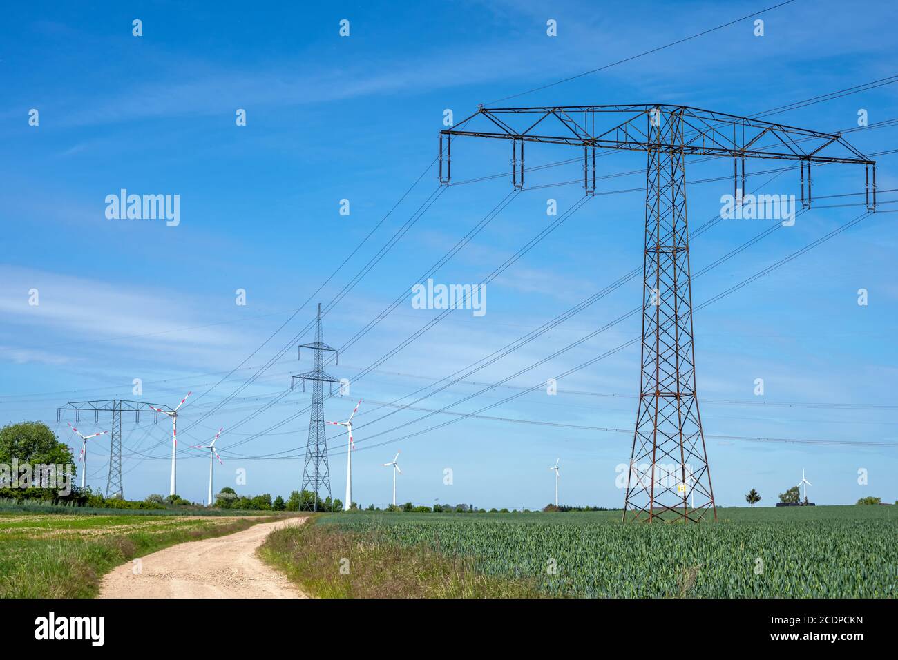 Linee elettriche aeree e alcune turbine eoliche moderne viste in Germania Foto Stock