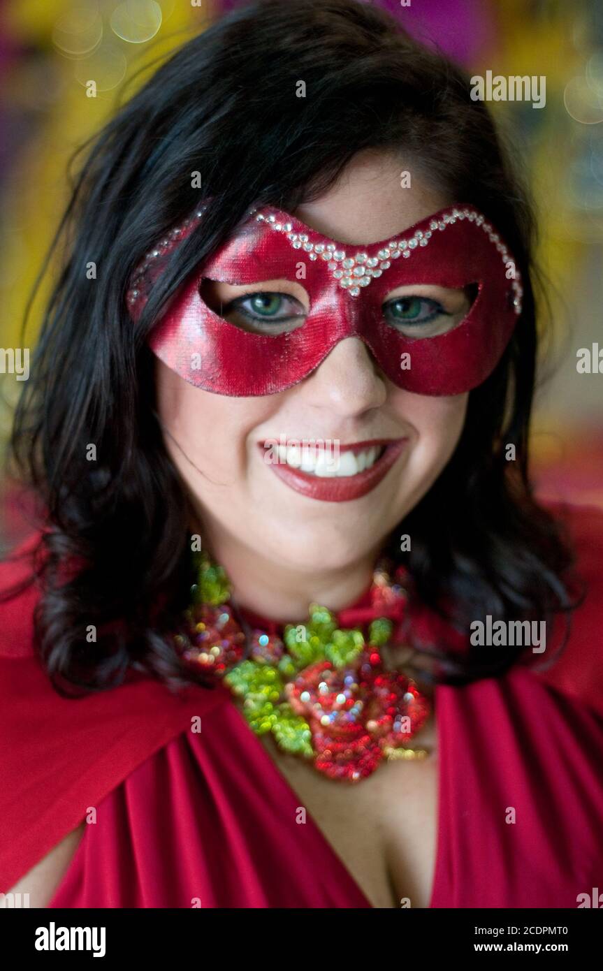 Un ritratto di una giovane donna che indossa un costume rosso di Mardi Gras e maschera oculare durante il festival a Shreveport, Louisiana, Stati Uniti. Foto Stock