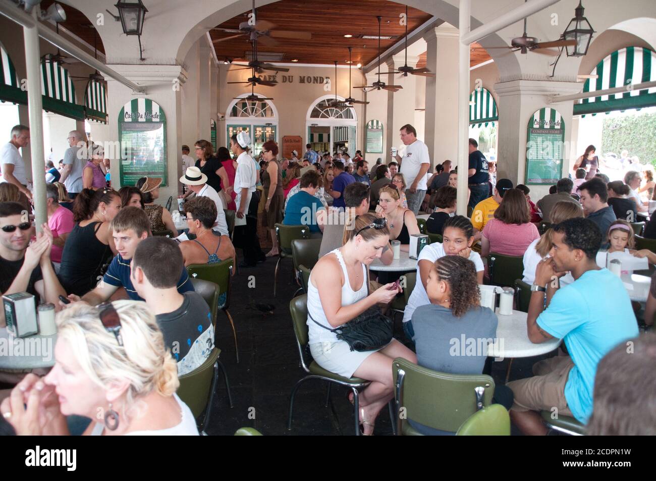 Persone sedute a tavoli all'aperto presso la famosa caffetteria Cafe Du Monde in Decatur Street nel quartiere francese di New Orleans, Louisiana, USA. Foto Stock
