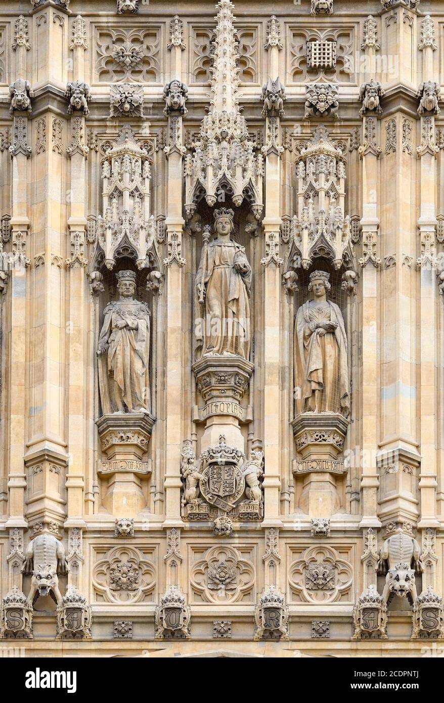 Londra, Inghilterra, Regno Unito. Statue sopra l'ingresso del Sovrano alle Camere del Parlamento sotto la Torre Victoria. Regina Victoria fiancheggiata dal suo par... Foto Stock