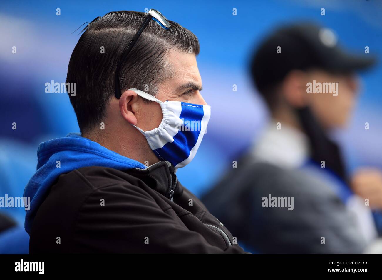 Un fan che indossa una maschera prende il suo posto negli stand con misure di divaricamento sociale prima durante il pre-stagione amichevole all'AMEX Stadium di Brighton, dove fino a 2500 tifosi sono stati autorizzati a guardare la partita dopo che il governo ha annunciato un ulteriore lotto di eventi sportivi che sarà utilizzato per pilotare il ritorno sicuro degli spettatori. Foto Stock