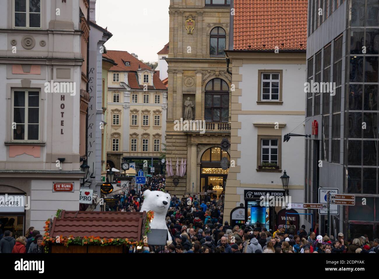 Praga, Czechia - 27.10.2018: Turisti che camminano da un uomo vestito da un gigantesco costume da orso polare a Praga Foto Stock