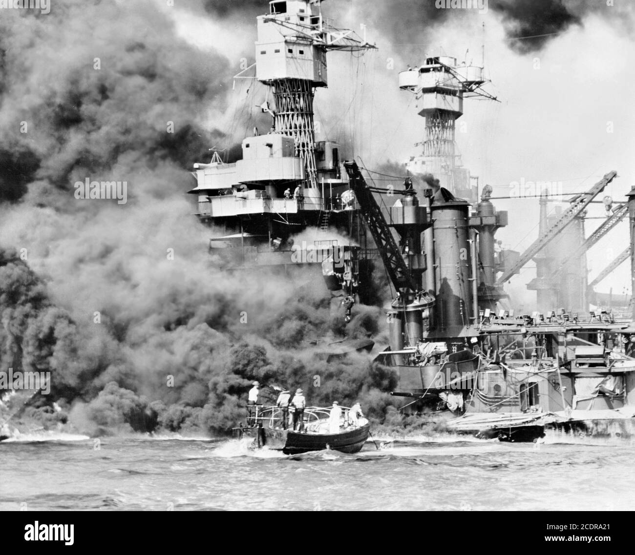 Pearl Harbor 1941. Una piccola barca che salva un marinaio dalla USS West Virginia, bruciando sullo sfondo, dopo l'attacco giapponese a Pearl Harbor, 7 dicembre 1941. Foto Stock