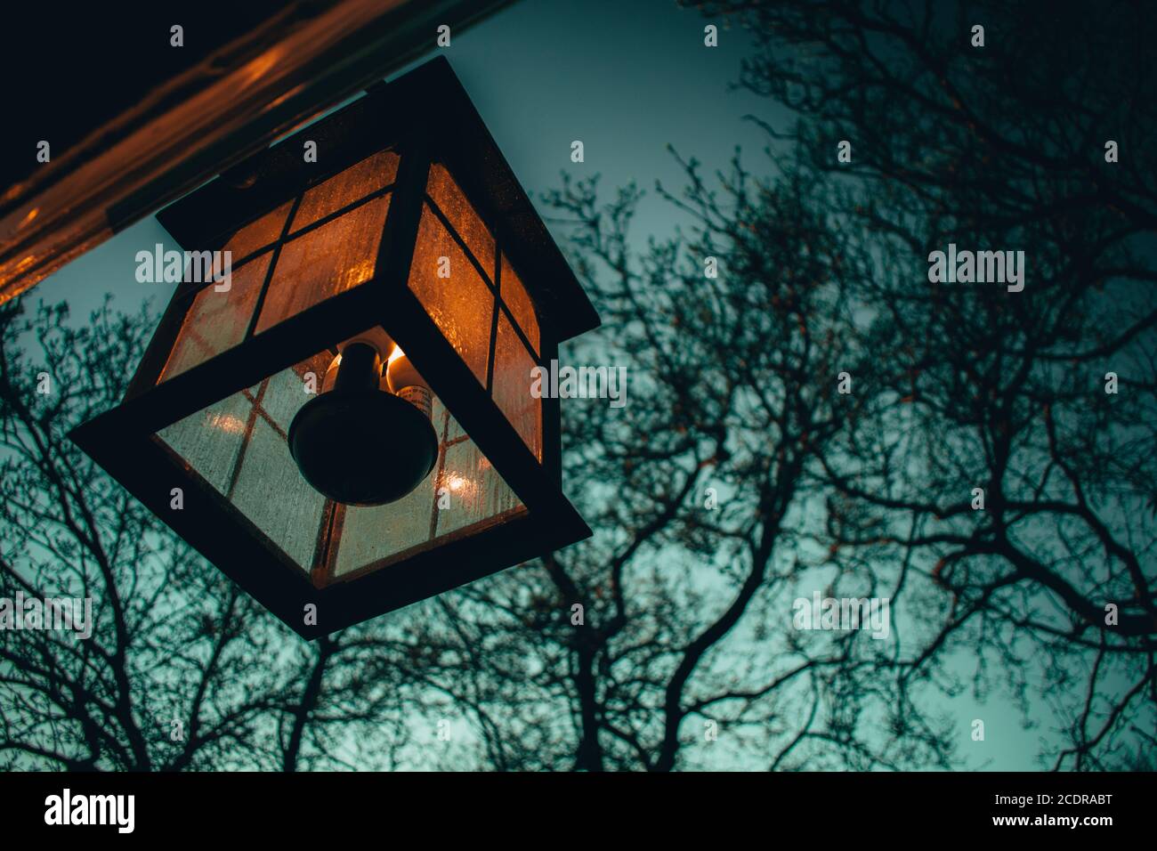 Una vecchia lampada di vetro che si aggancia sul lato di a. Casa Foto Stock