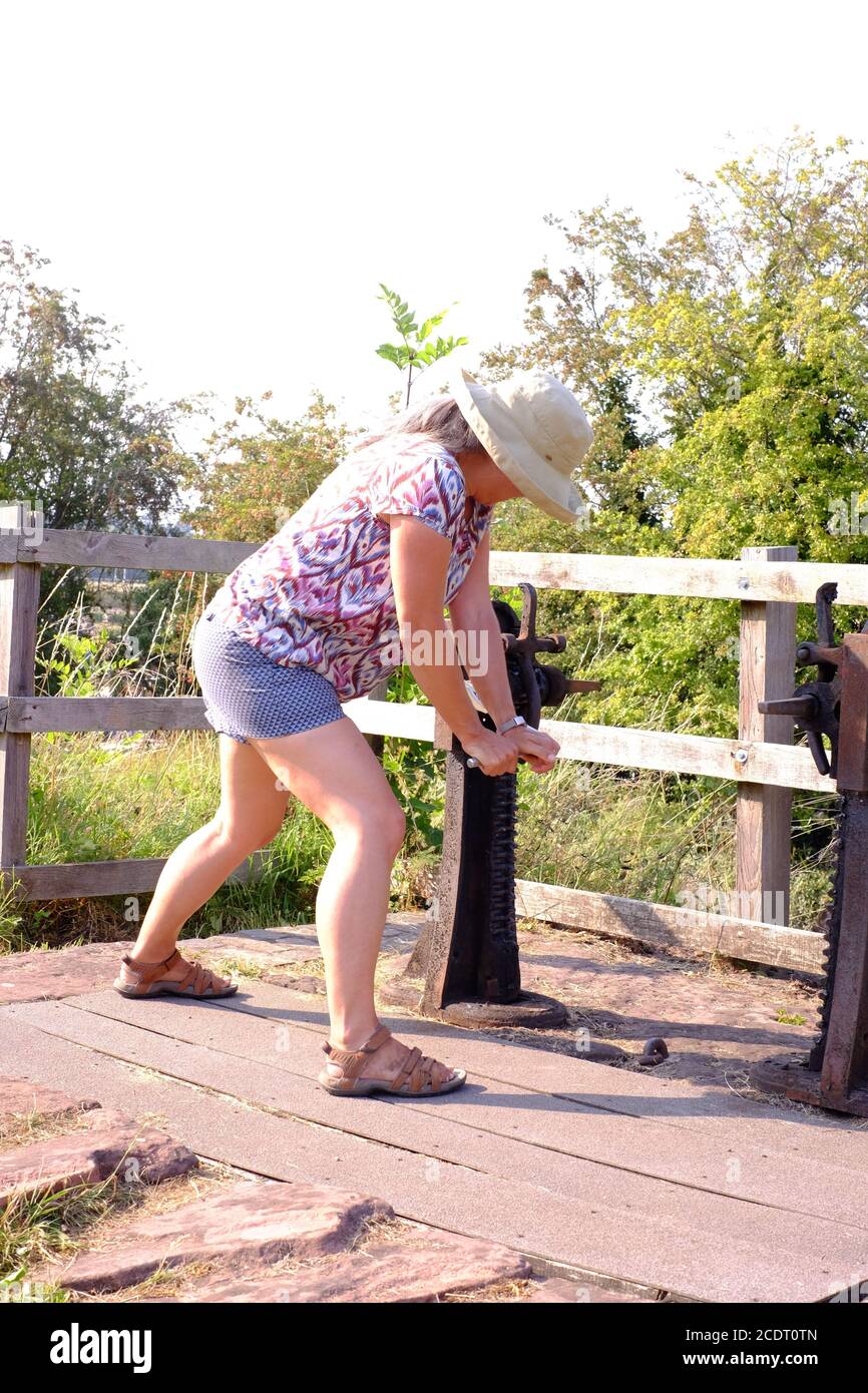 Donna che aziona il blocco del canale utilizzando un utensile a ventosa per spostare le palette del punto di iniezione a otturazione. Foto Stock