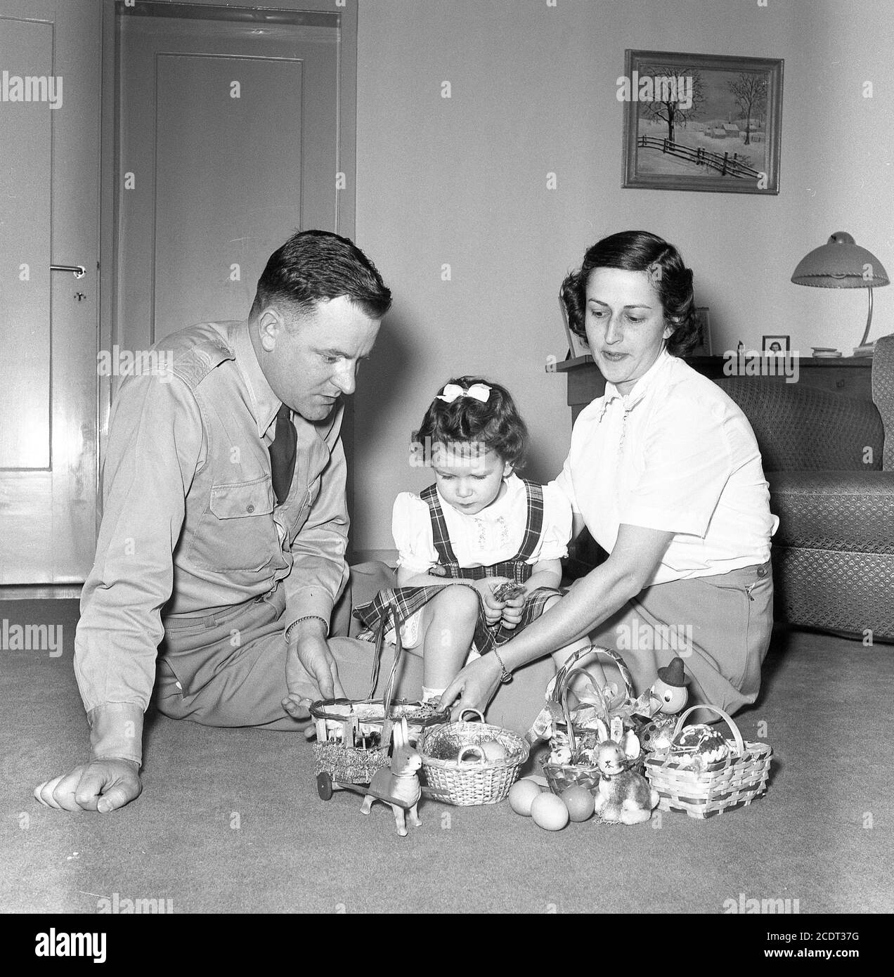 Ufficiale militare dell'esercito e moglie posano con il bambino giovane e cesti di Pasqua, U.S.A. 1950 Foto Stock