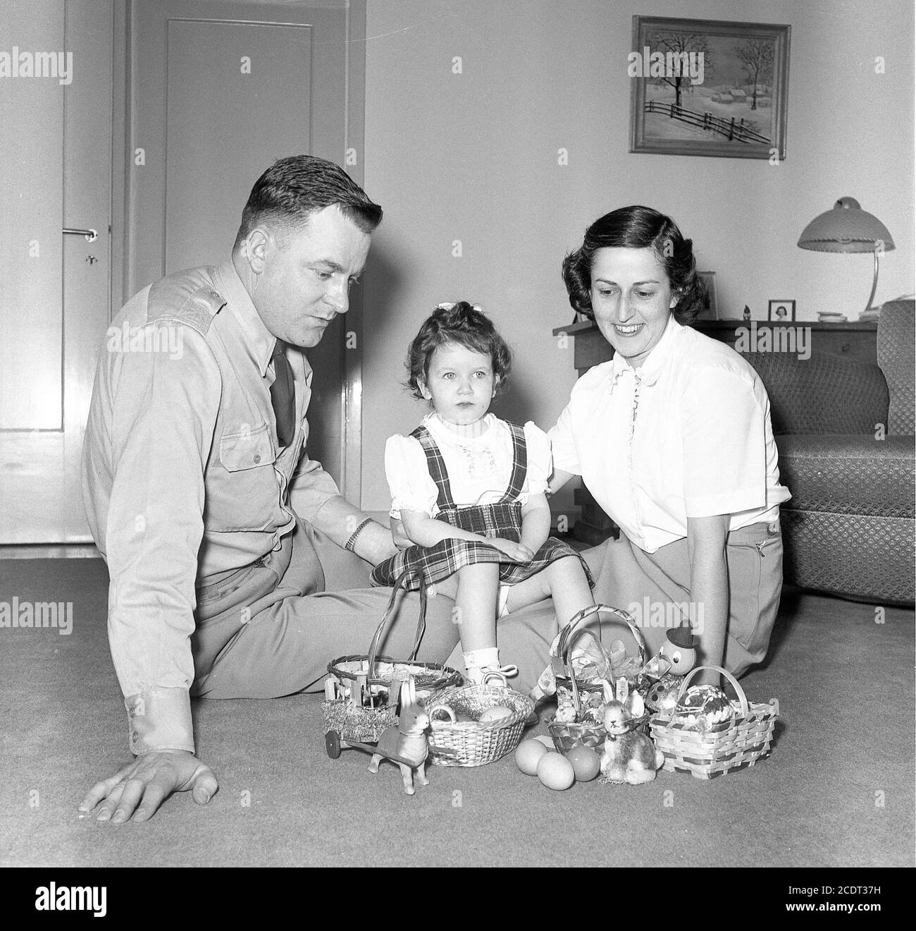 Ufficiale militare dell'esercito e moglie posano con il bambino giovane e cesti di Pasqua, U.S.A. 1950 Foto Stock