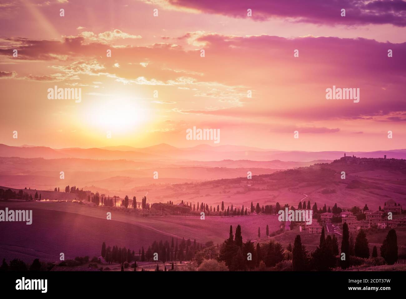 Meraviglioso paesaggio toscano con cipressi, fattorie e borghi medievali, Italia. Tramonto rosa e viola Foto Stock
