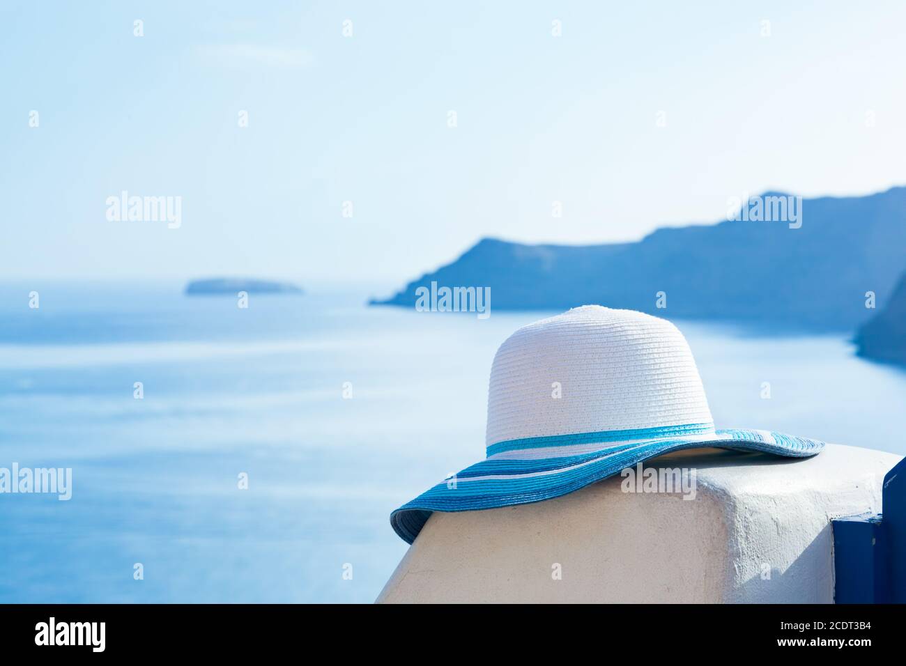 Cappello da sole su muro di pietra bianca sull'isola di Santorini, Grecia. Viaggi, turismo Foto Stock