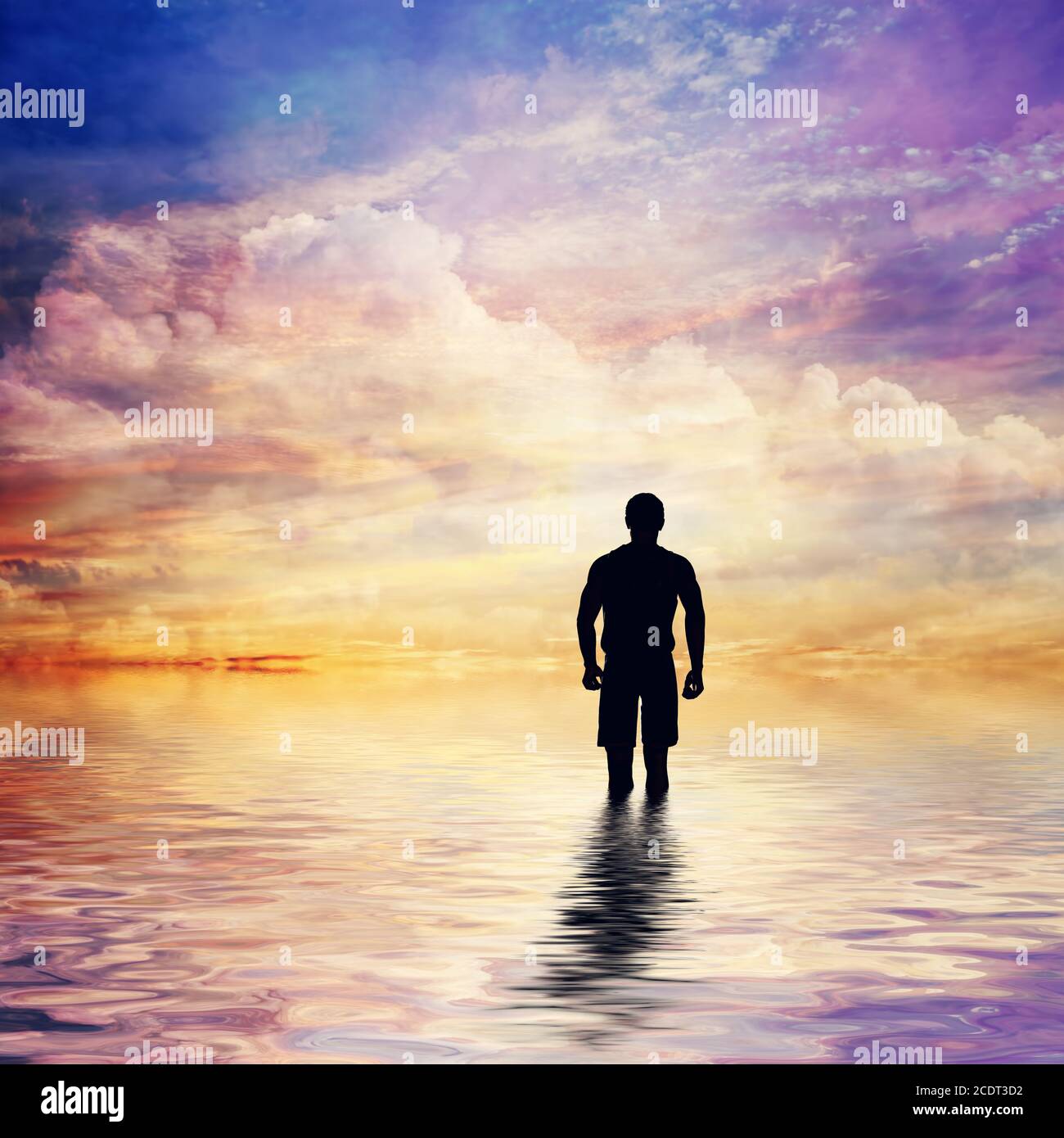 Uomo in acqua di calmo oceano guardando la fiaba, fantastico cielo tramonto. Foto Stock