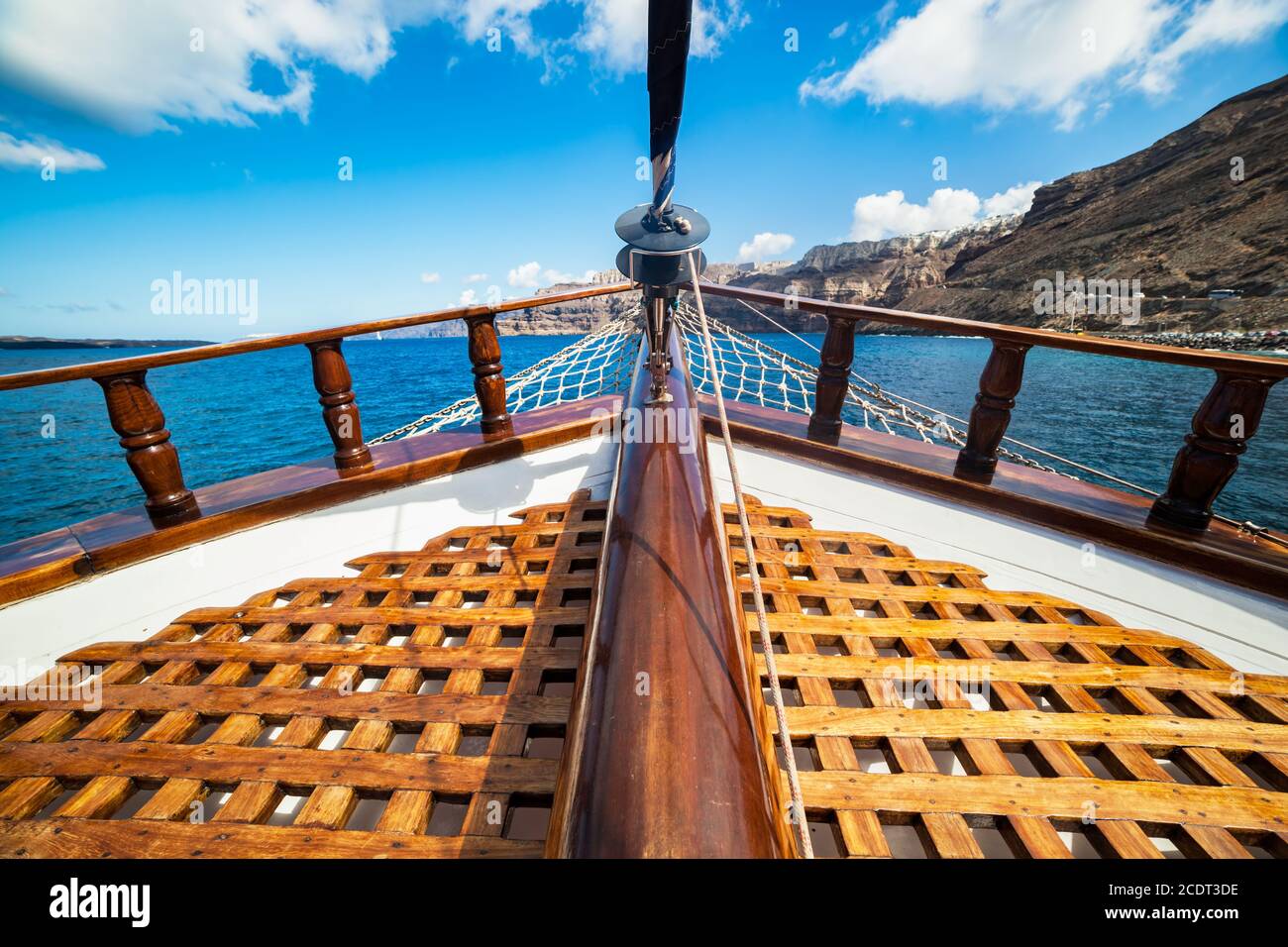 Vista a bordo da una nave tradizionale che naviga sul mare Egeo accanto all'isola di Santorini. Foto Stock