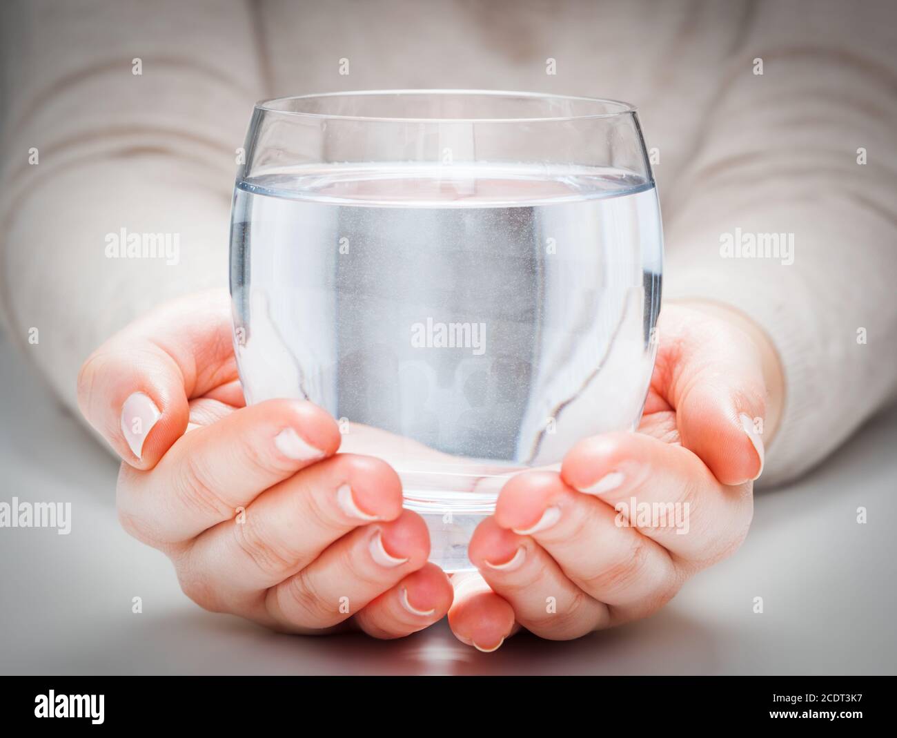 Un bicchiere di acqua minerale pulita nelle mani della donna n° 39. Protezione dell'ambiente, bevanda sana. Foto Stock