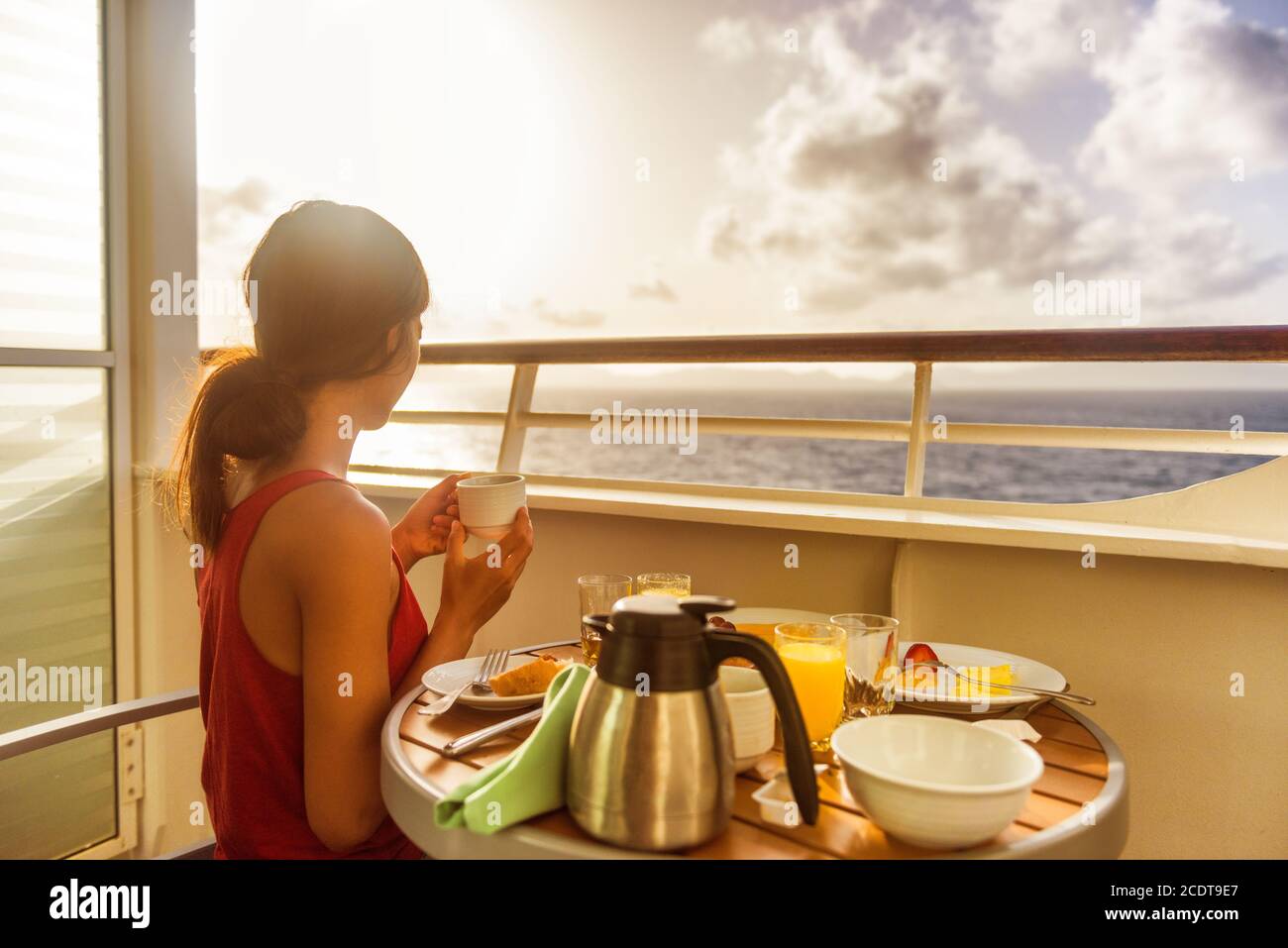 Nave da crociera di lusso donna di viaggio mangiare la prima colazione dal servizio in camera sul balcone della suite godendo di vista mattutina dell'oceano caraibico. Vacanza estiva in barca a vela Foto Stock