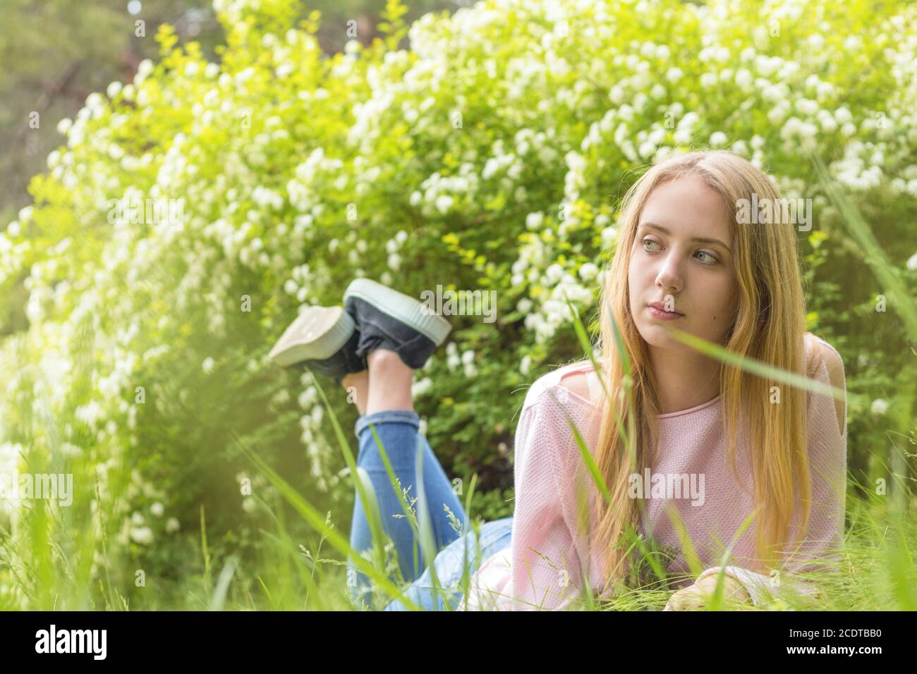 Bella ragazza-adolescente bionda sognare in una giornata di sole sul erba Foto Stock