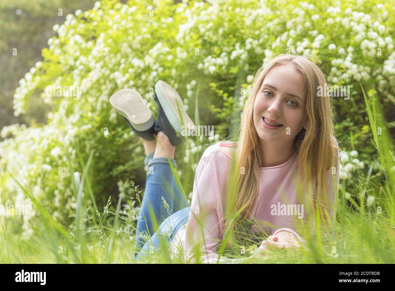 Bella ragazza-adolescente bionda sognare in una giornata di sole sul erba Foto Stock