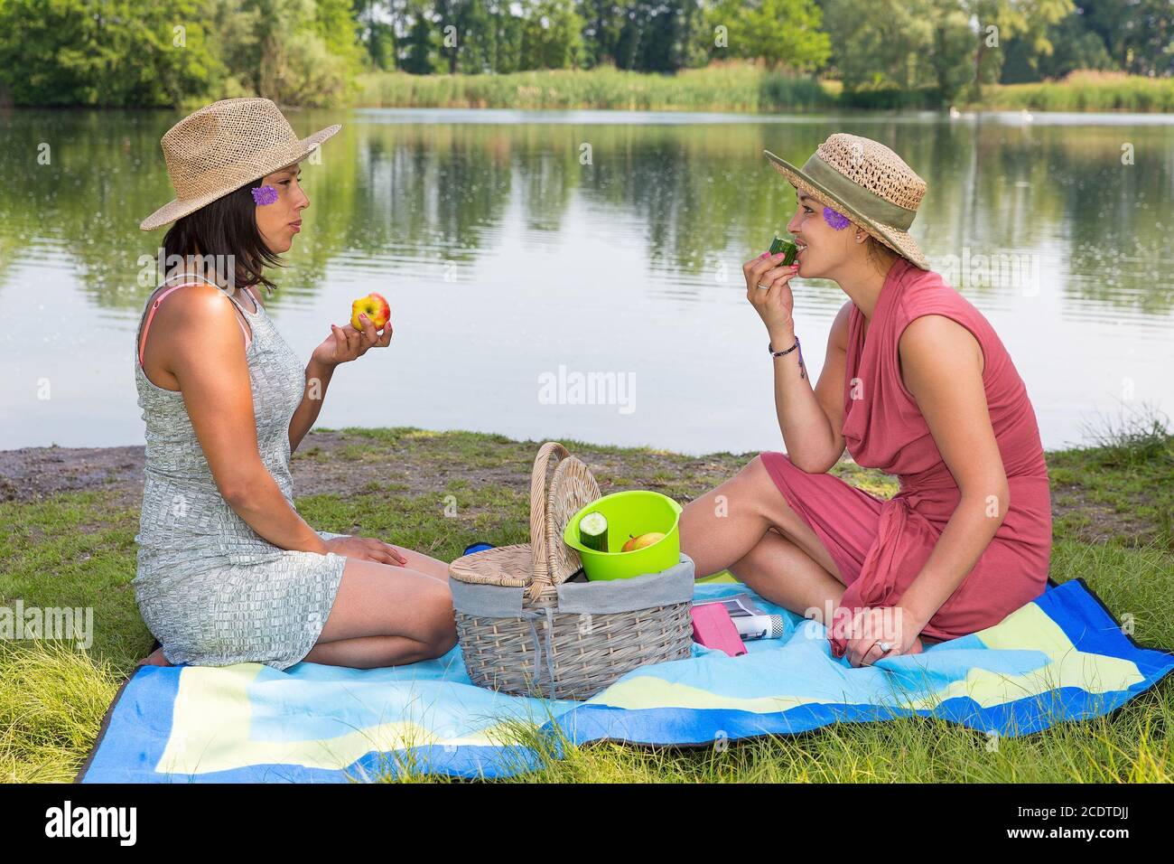 Due donne picknick sul lato dell'acqua Foto Stock