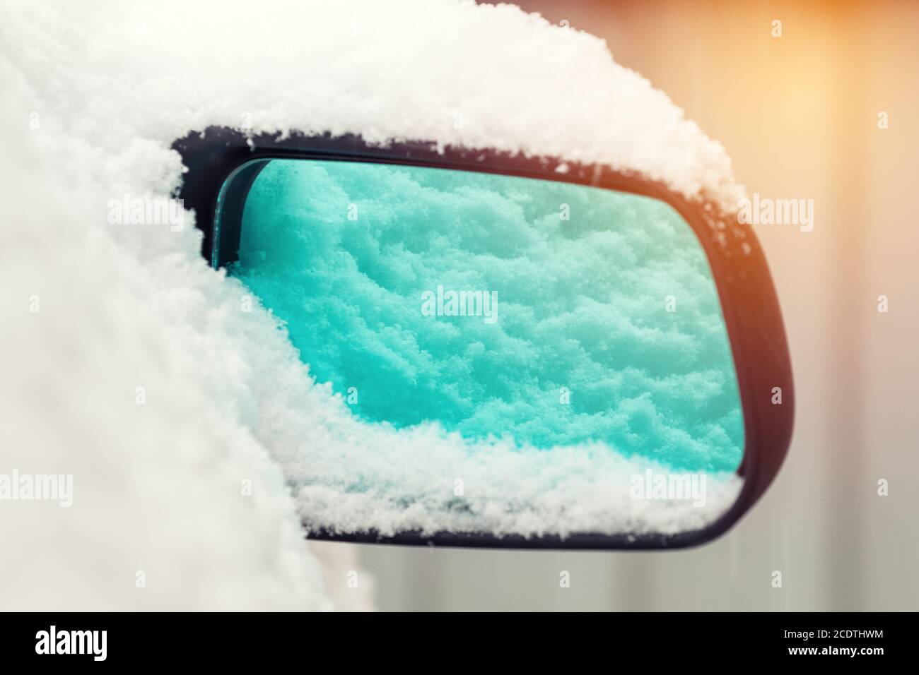 L'auto è coperta di neve. Neve sullo specchietto retrovisore. Concetto di guida in inverno con neve su strada. Foto a colori con Foto Stock