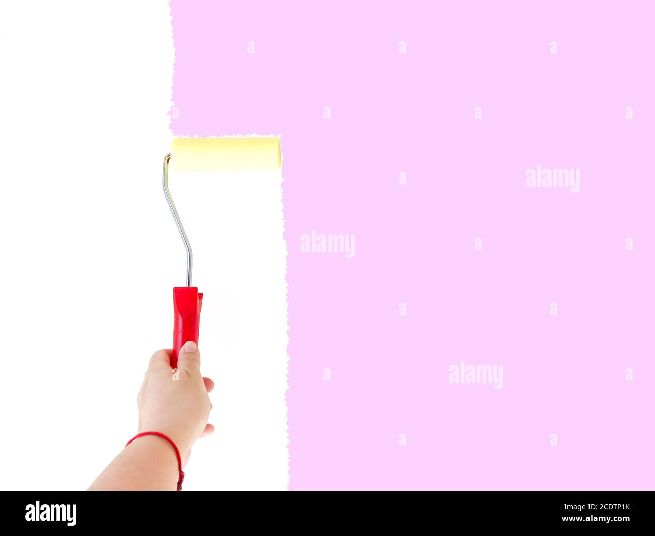 Una persona che dipinge una parete bianca con una spazzola a rullo Foto Stock