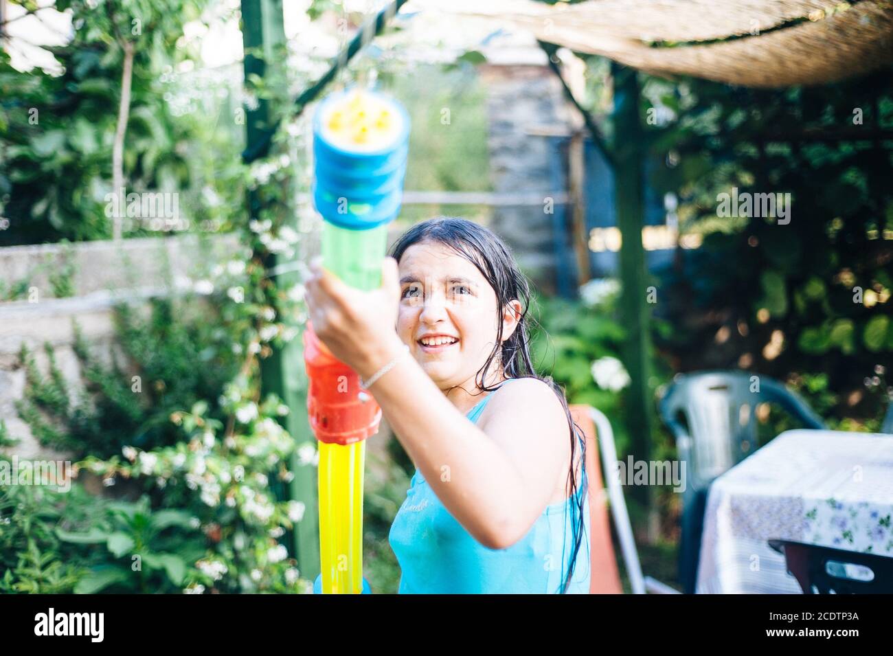 i bambini giocano in giardino con pistole e fucili ad acqua in una soleggiata giornata estiva Foto Stock