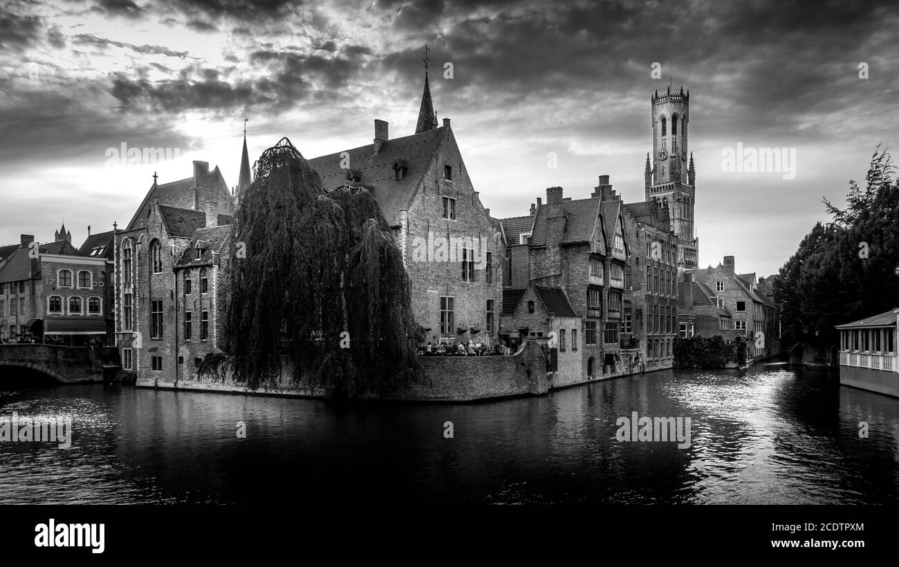 Foto in bianco e nero degli edifici storici e della Torre Belfort vista dal canale Dijver nella città medievale di Bruges, Belgio Foto Stock