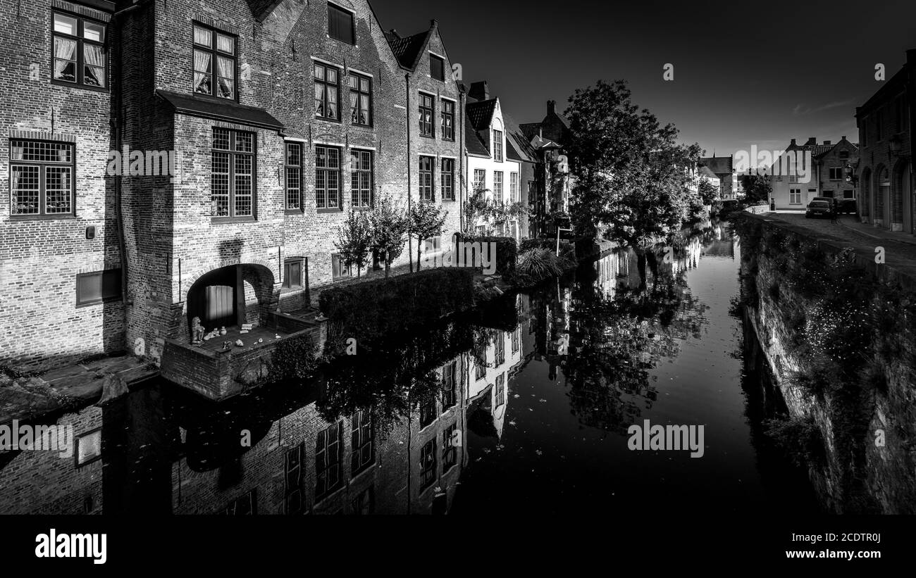 Bianco e nero Foto di case medievali che si riflettono nelle acque di un canale a Bruges, Belgio Foto Stock