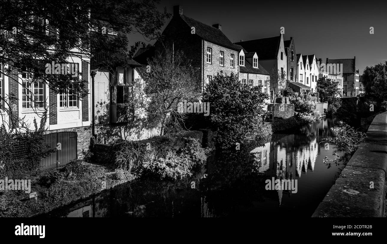 Bianco e nero Foto di case medievali che si riflettono nelle acque di un canale a Bruges, Belgio Foto Stock