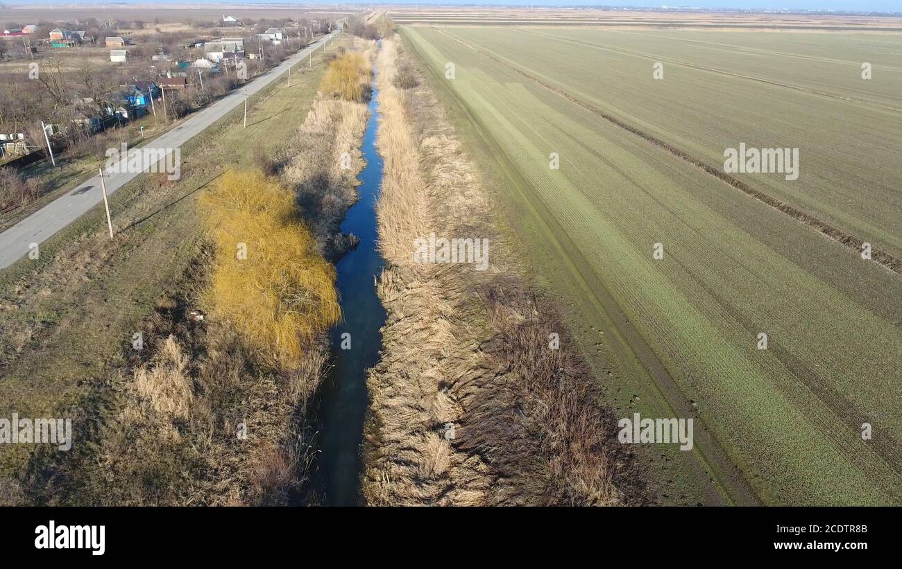 Il canale del livello inferiore del sistema di irrigazione dei campi. Infrastrutture per la coltivazione del riso Foto Stock