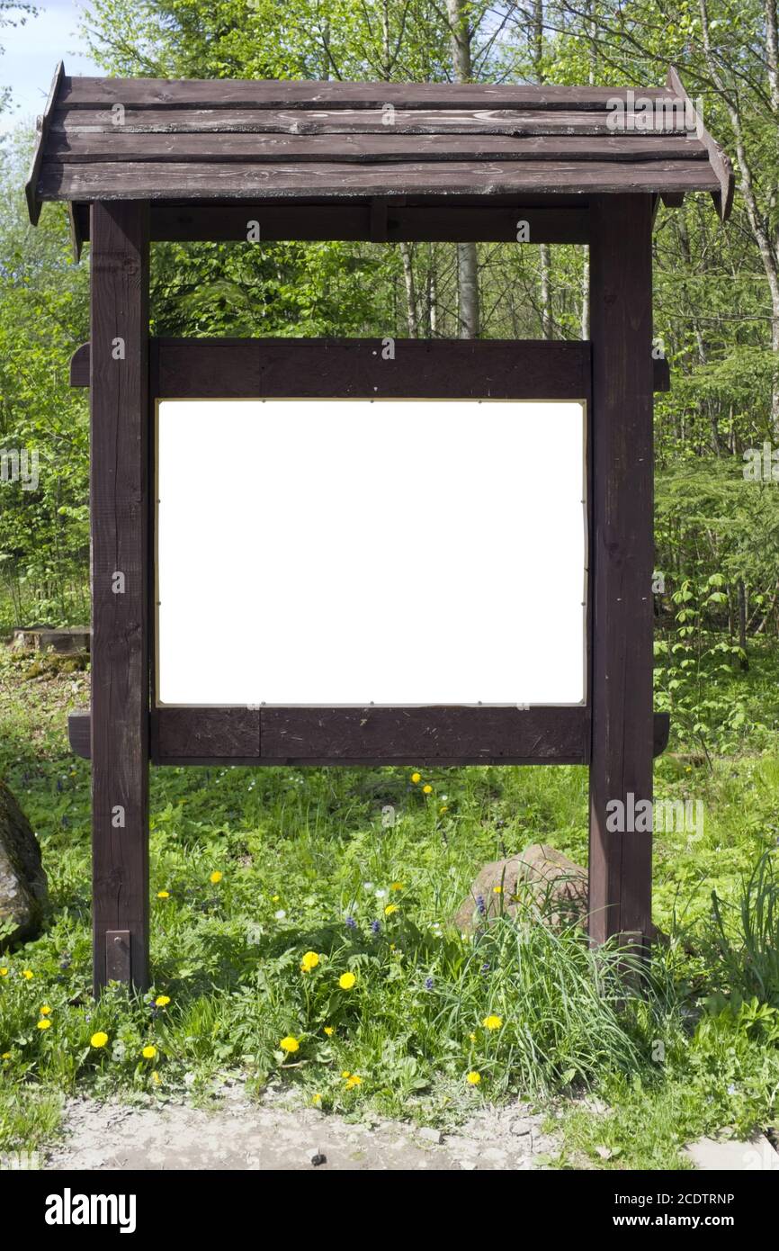 Sulla radura primaverile della foresta c'è un vecchio stand di legno marrone con informazioni. Foto Stock Sulla radura primaverile della foresta c'è un vecchio stand di legno marrone con informazioni. Foto Stock