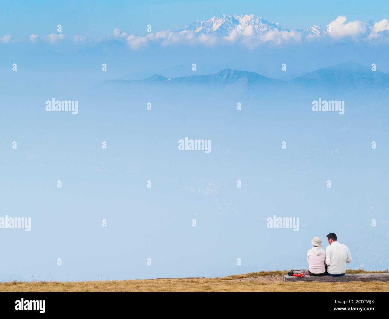 Un paio di giovani turisti sulle montagne svizzere, osservano il paesaggio delle Alpi di fronte a loro Foto Stock