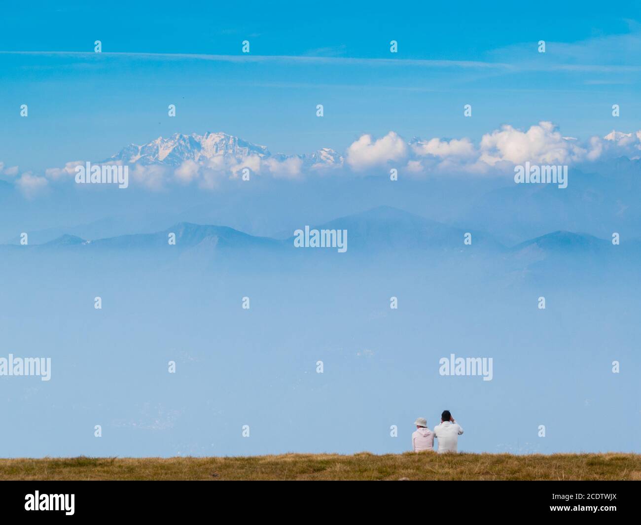 Un paio di giovani turisti sulle montagne svizzere, osservano il paesaggio delle Alpi di fronte a loro Foto Stock