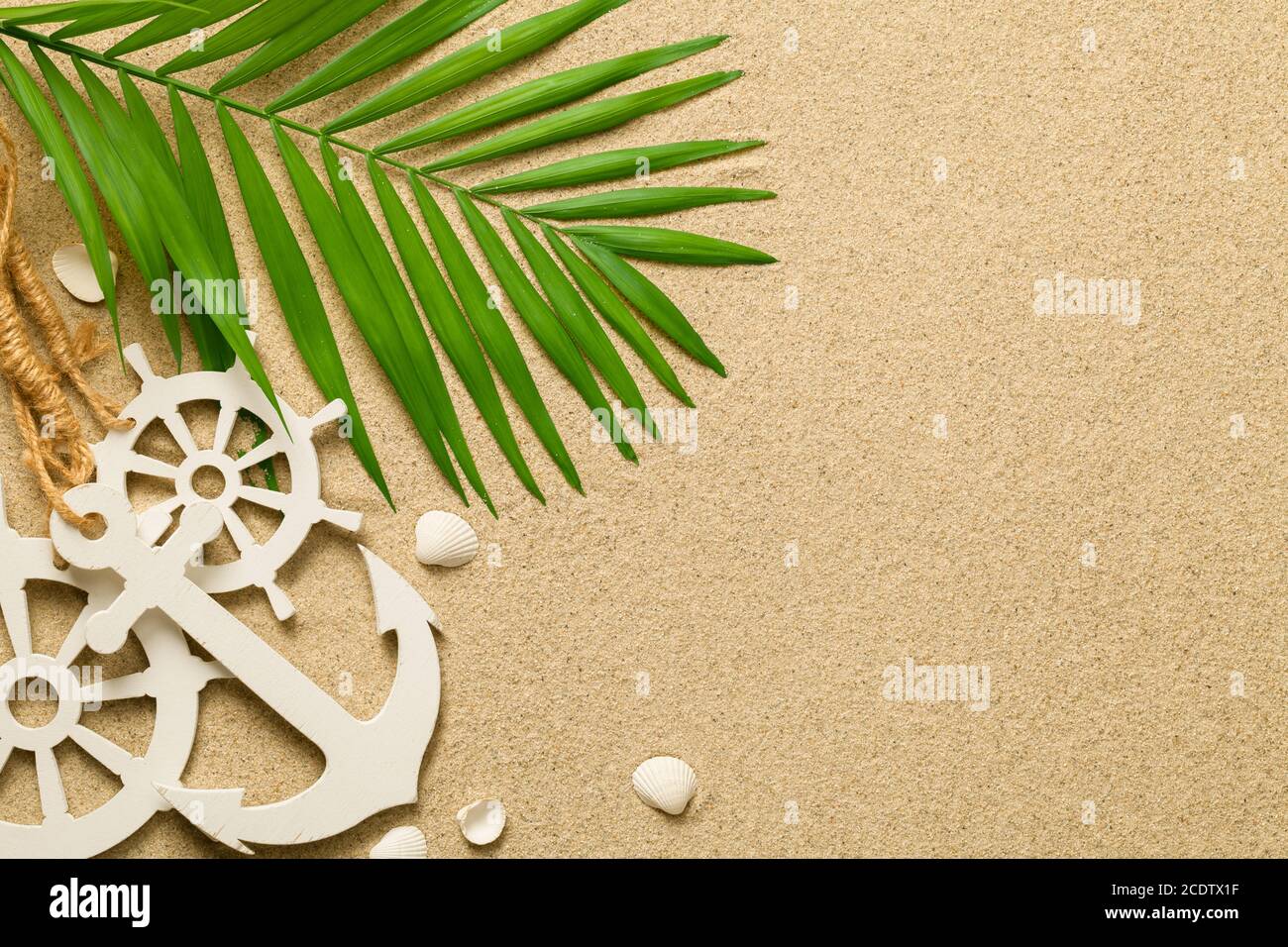 Sfondo estivo con foglie di palma verdi, ancoraggio decorativo e ruote sterzanti navicelle Foto Stock