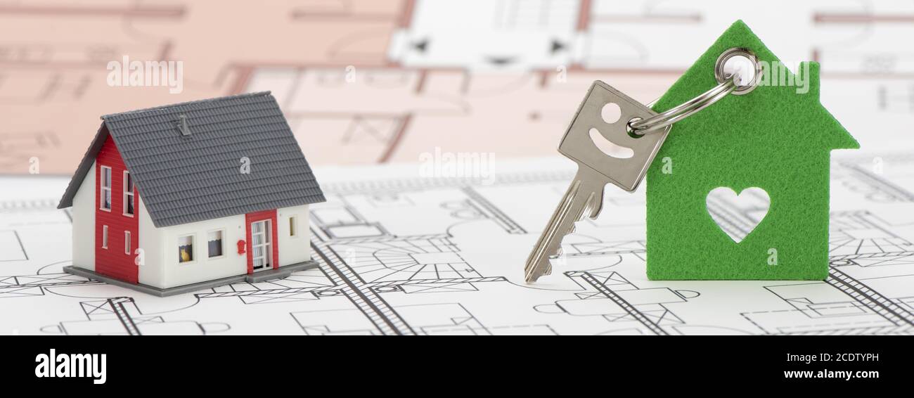 Modello di casa e tasto home la posa su piano di costruzione Foto Stock