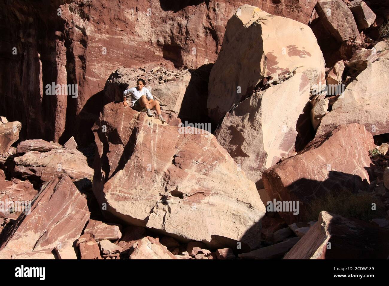 Giovane donna boulder hopping vicino Upper Tapeats Campground nel Grand Canyon National Park, Arizona. Foto Stock