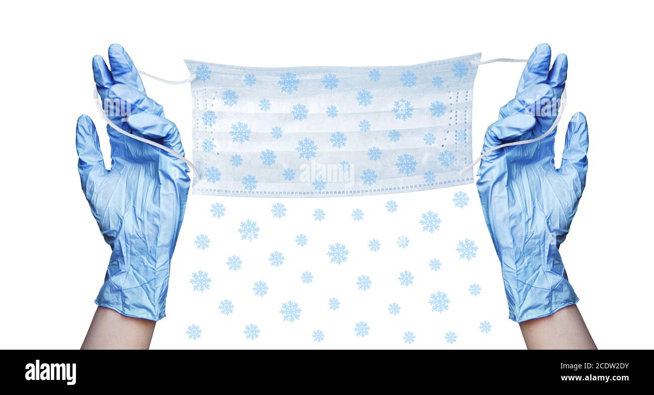 Mani in guanti medici di gomma blu, maschera chirurgica protettiva, modello di neve bianco sfondo isolato primo piano, protezione del coronavirus, Natale Foto Stock