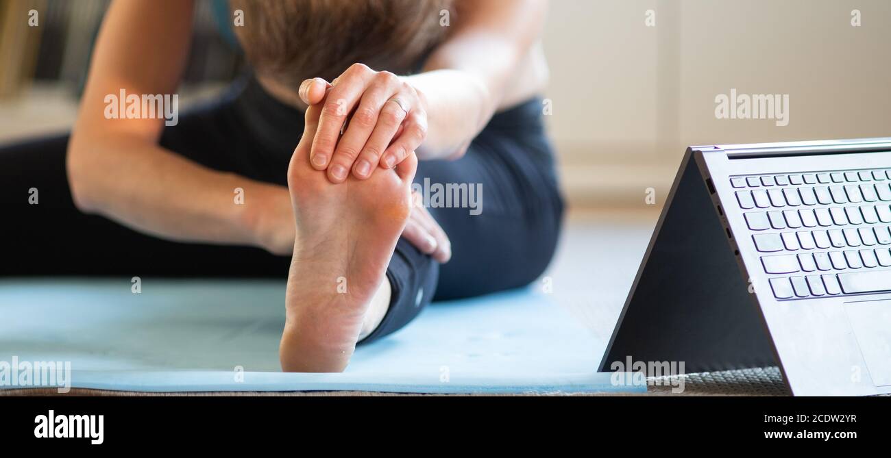 donna che fa yoga a casa guardando video online Foto Stock