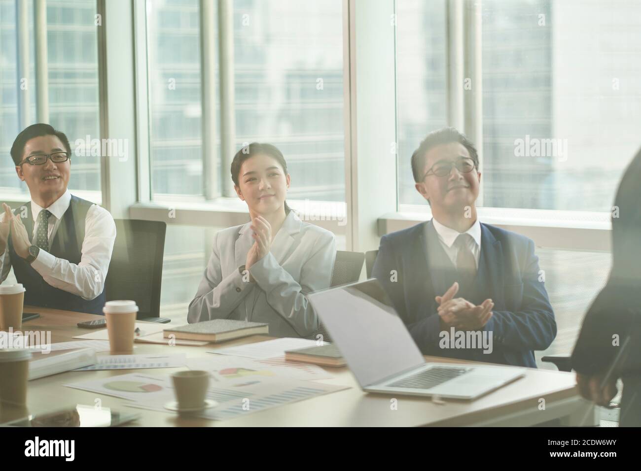 attraverso il vetro di una squadra di uomini d'affari asiatici riunione in ufficio Foto Stock