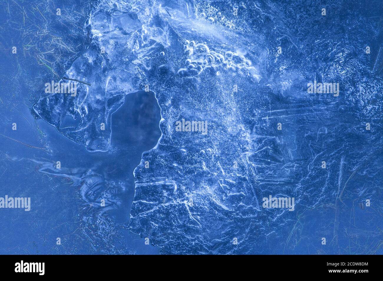 Rete di incrinature nel solido spesso congelati strato di ghiaccio con luce splendente nella forma della testa del cavallo Foto Stock