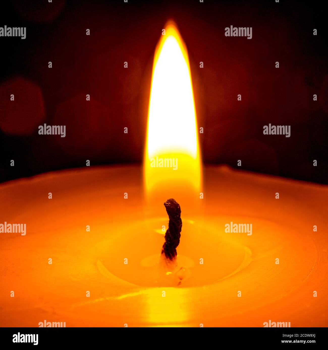 La fiamma di una candela che brucia su uno sfondo nero primo piano Foto Stock