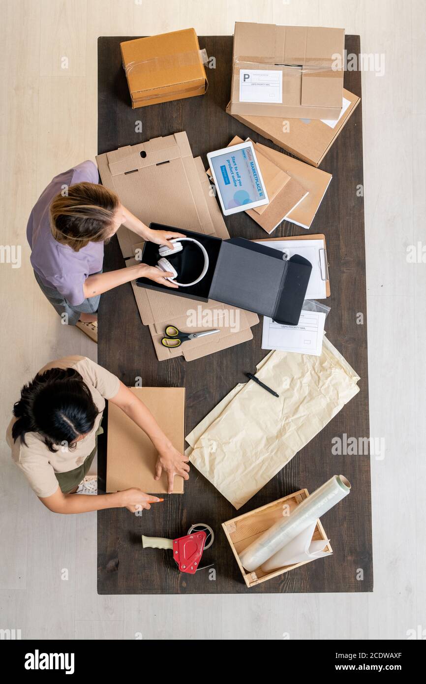 Vista dall'alto di due giovani manager femminili del negozio online ordini di imballaggio dei clienti Foto Stock