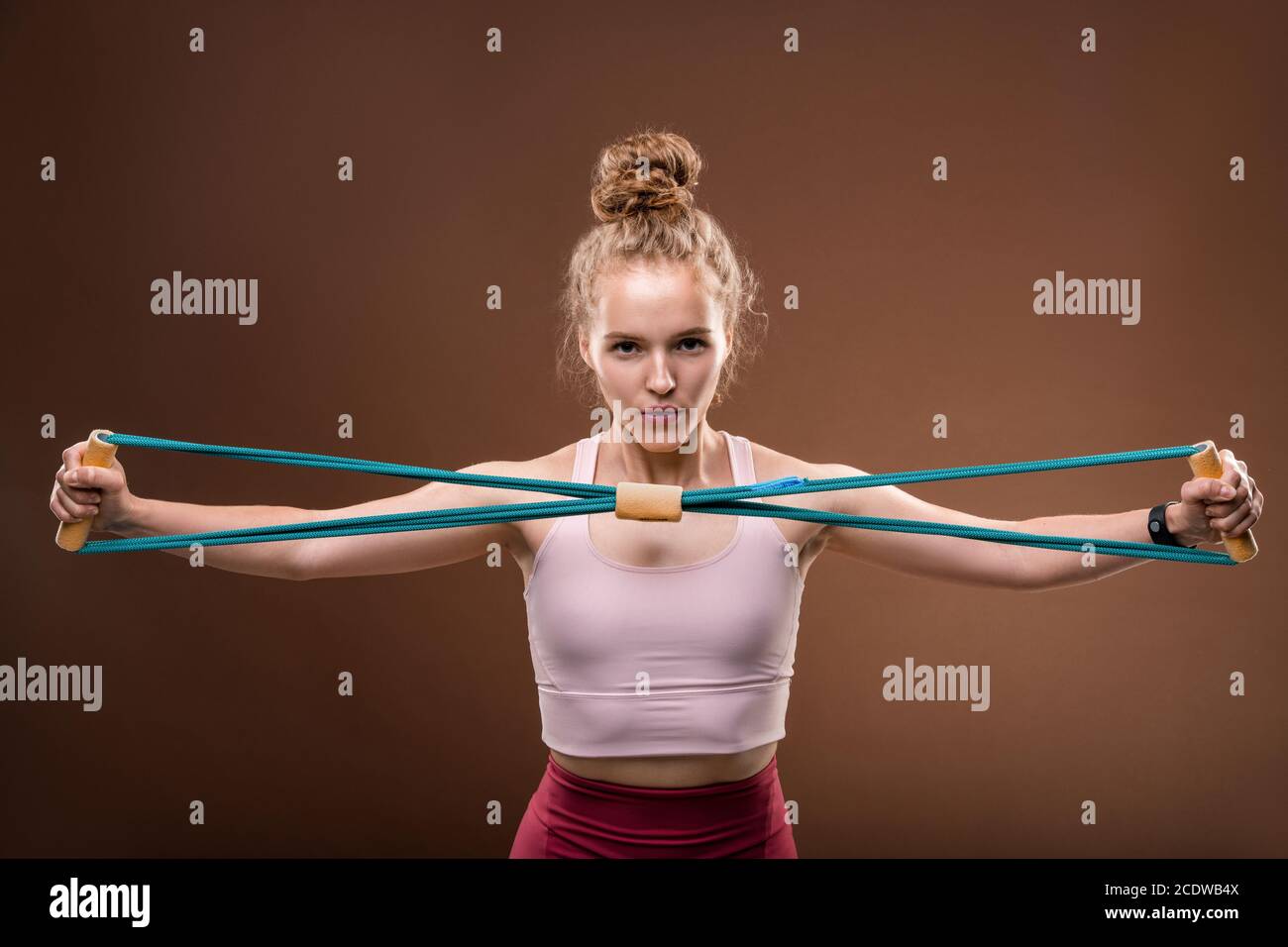 Giovane donna attiva in tuta stretching elastico davanti di se stessa Foto Stock