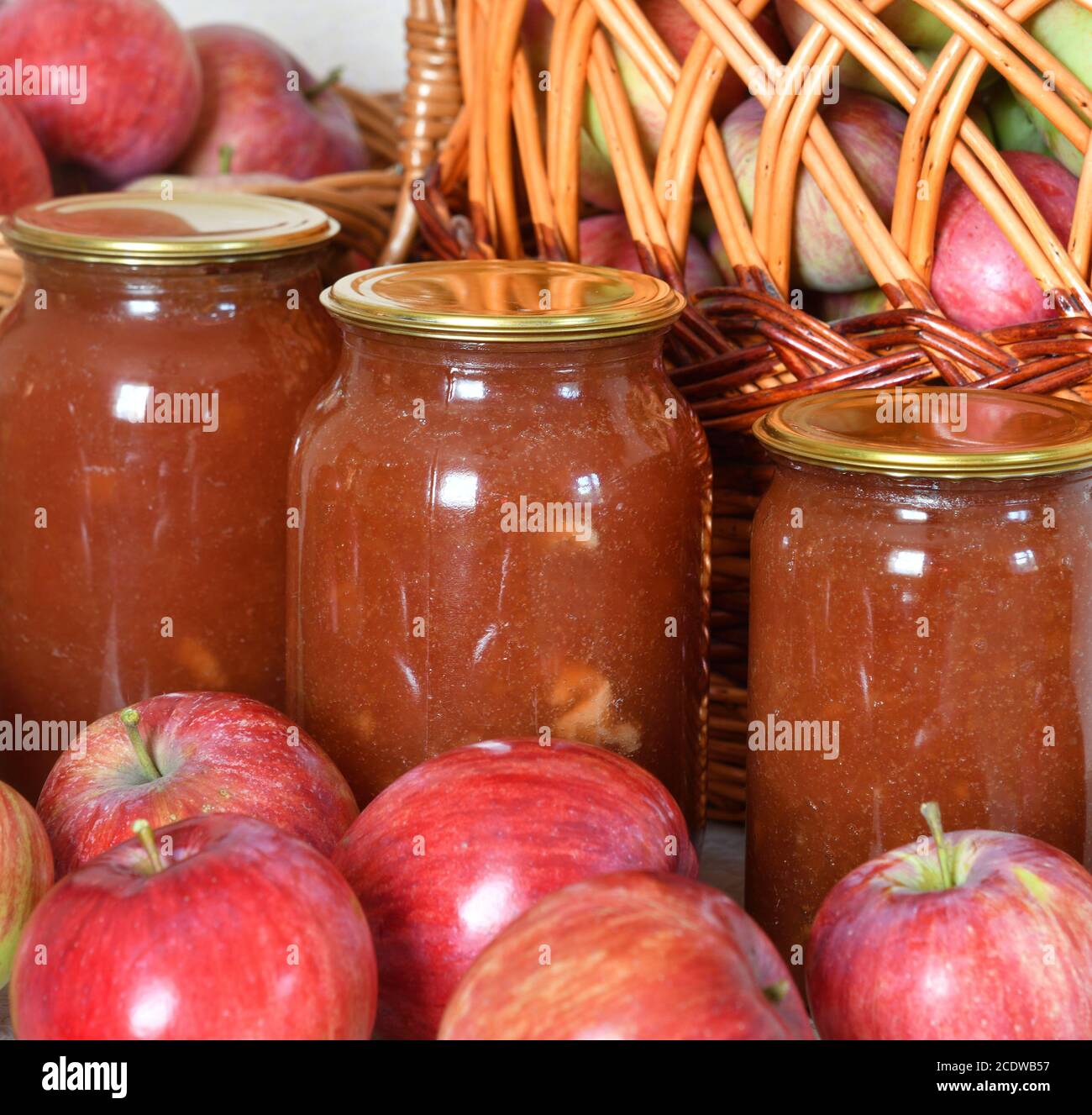 marmellata di mele in vasi di vetro e un sacco di mele fresche Foto Stock