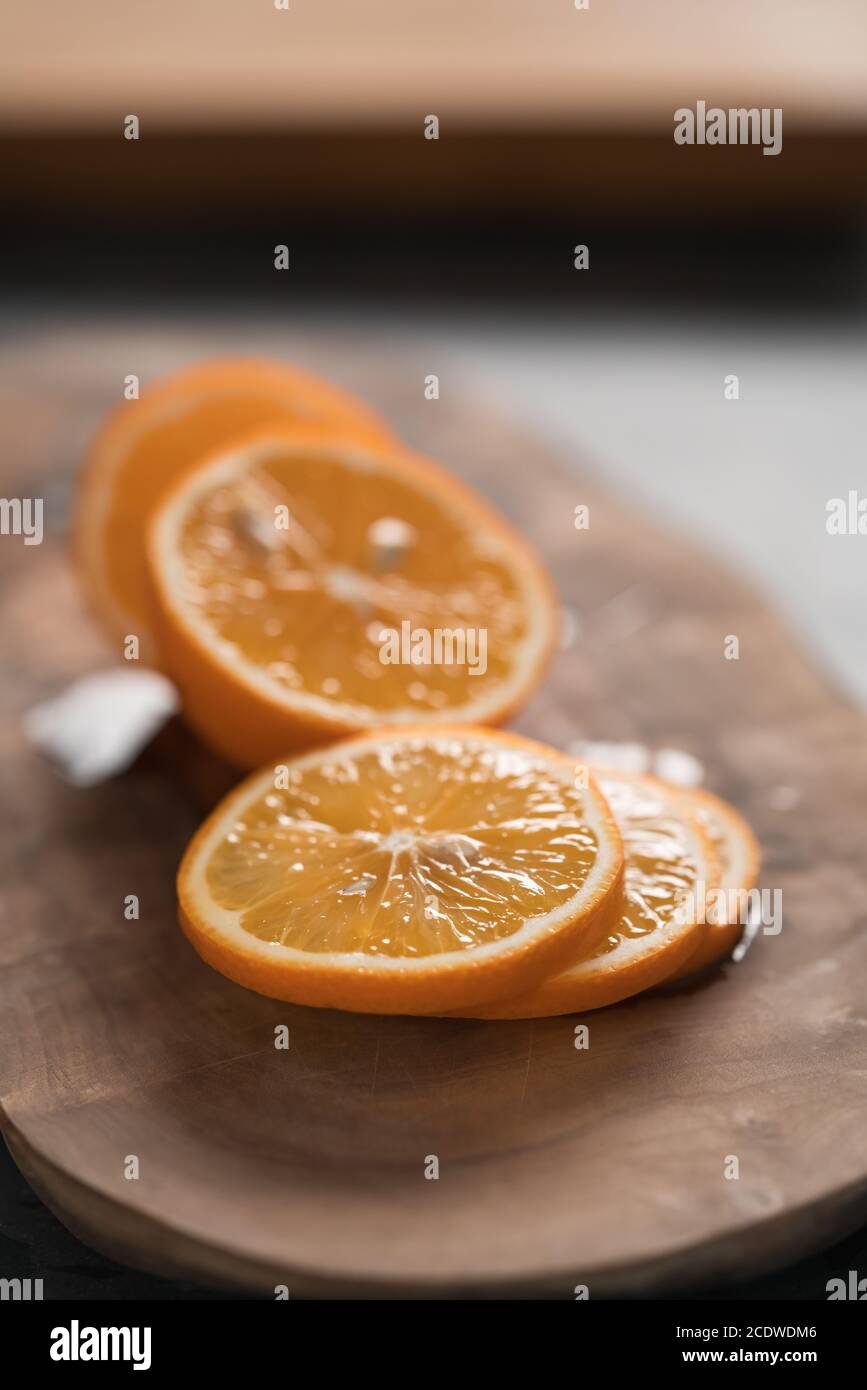 Limone arancione a fette su tavola di ulivo closeup, fuoco basso Foto Stock