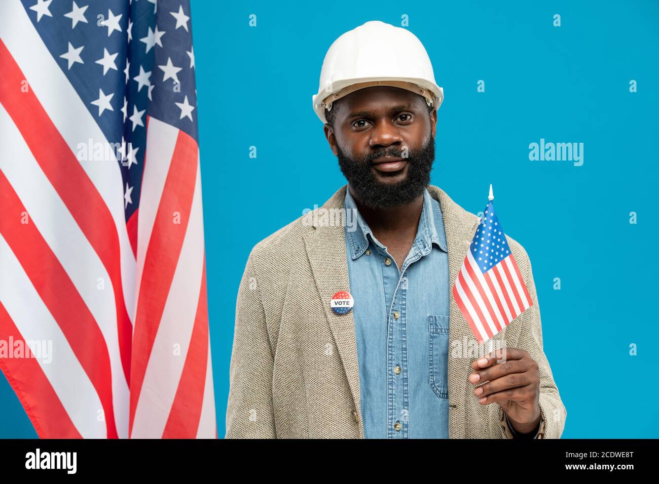 Costruttore africano contemporaneo in casco e abbigliamento da formalwear con bandiera americana Foto Stock