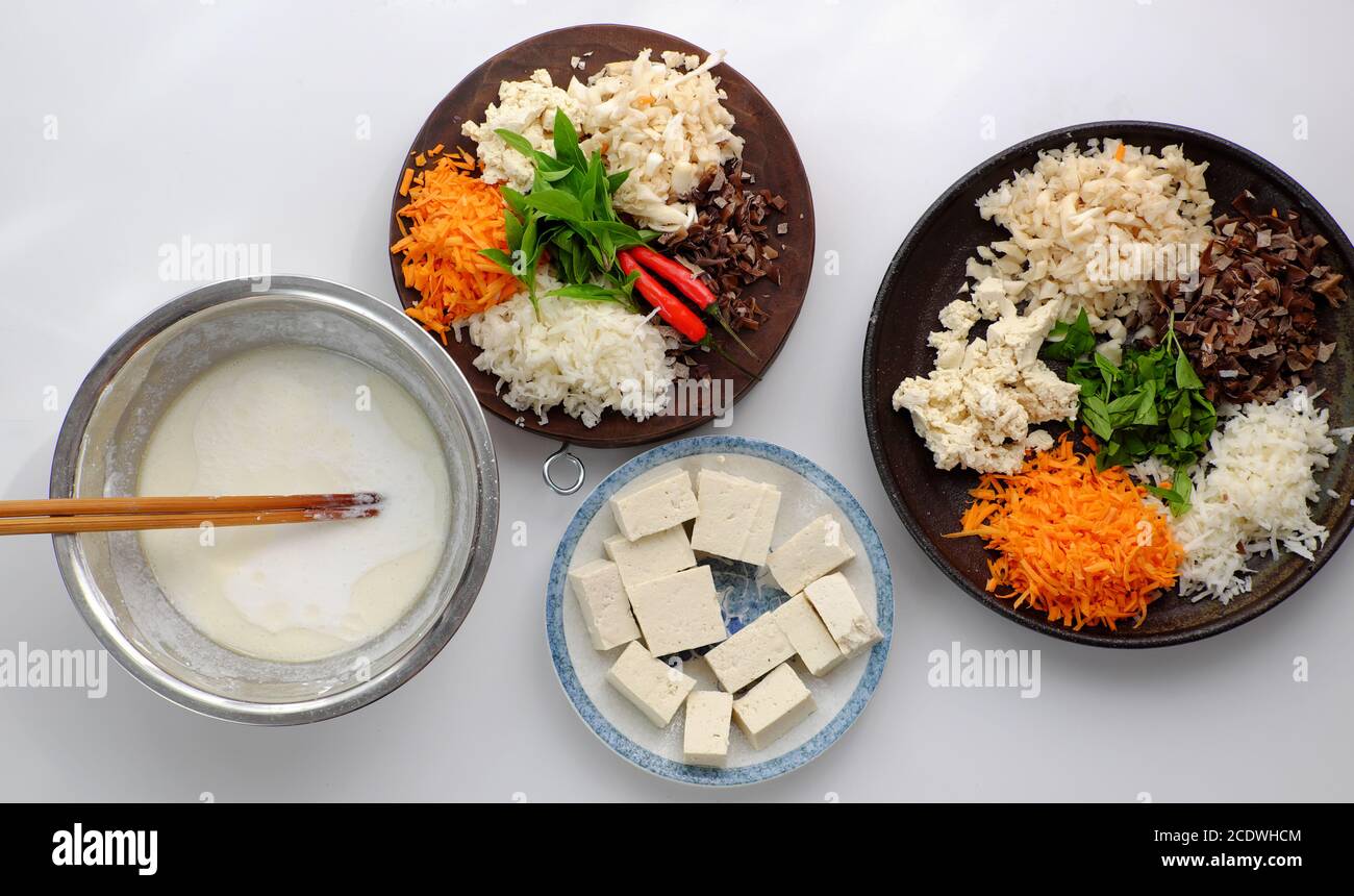 Vista dall'alto materia prima pronta a cucinare pasta di riso fatta in casa, ingrediente vegano, funghi, carote, pastella di riso, tofu, piatto popolare vietnamita Foto Stock