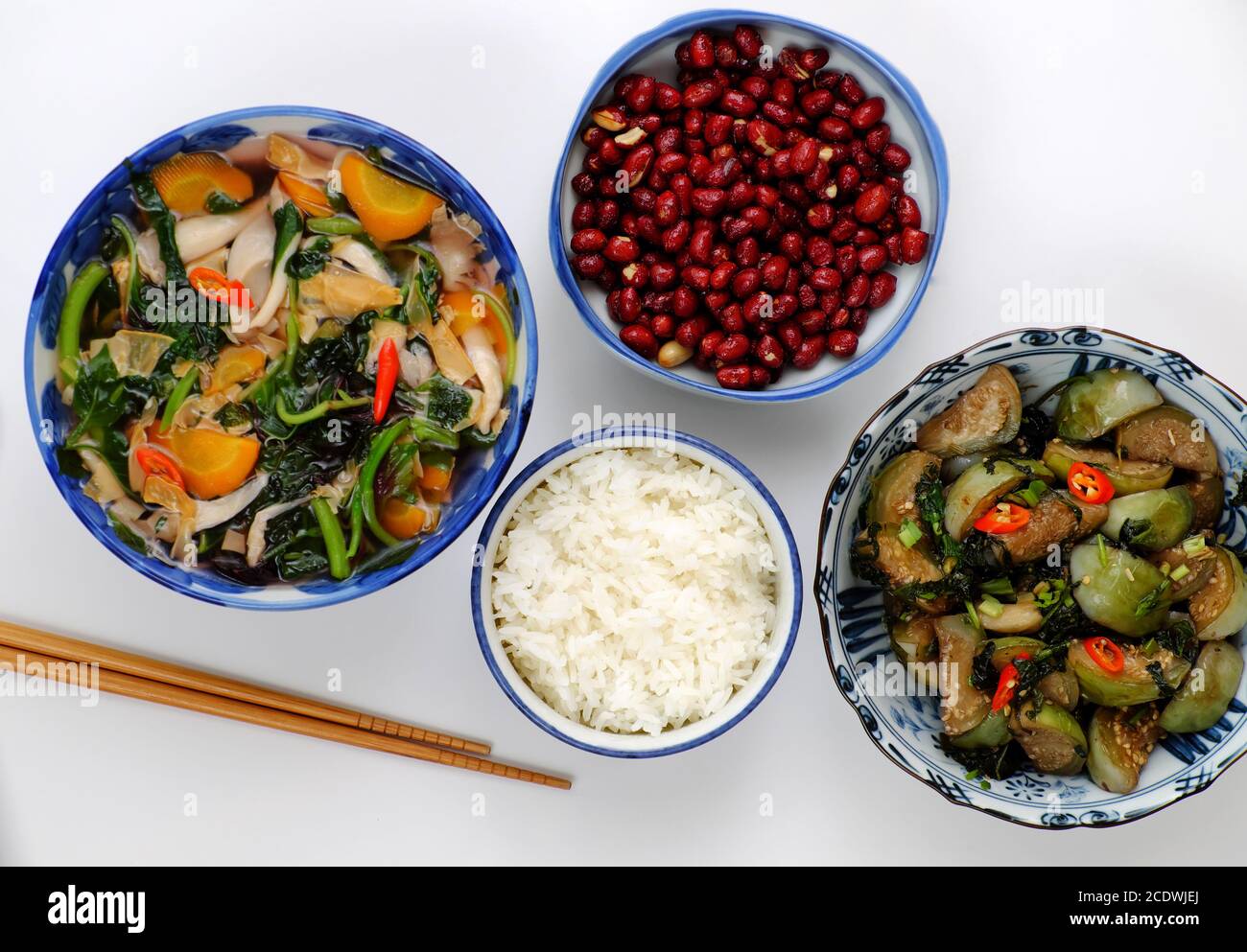 Pasto giornaliero vegano a pranzo, arachidi fritte con salsa, melanzane verdi fritte, ciotola di riso, zuppa di verdure, semplice cibo vegetariano vietnamita Foto Stock