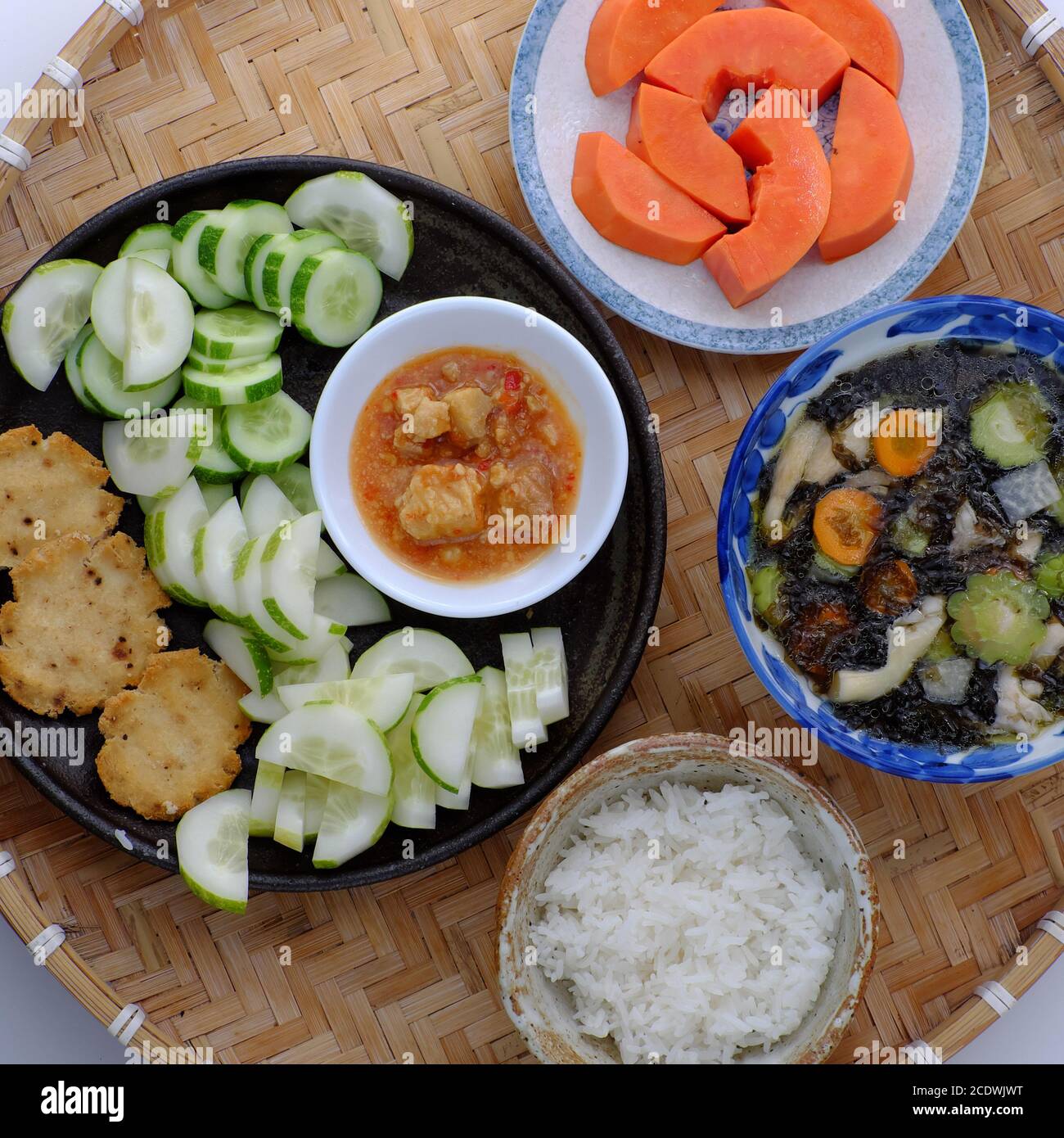 Vista dall'alto: Pasto giornaliero vegano per pranzo, fetta di cetriolo con formaggio tofu, zuppa di alghe, ciotola di riso, semplice cibo vegetariano vietnamita che nutrire Foto Stock