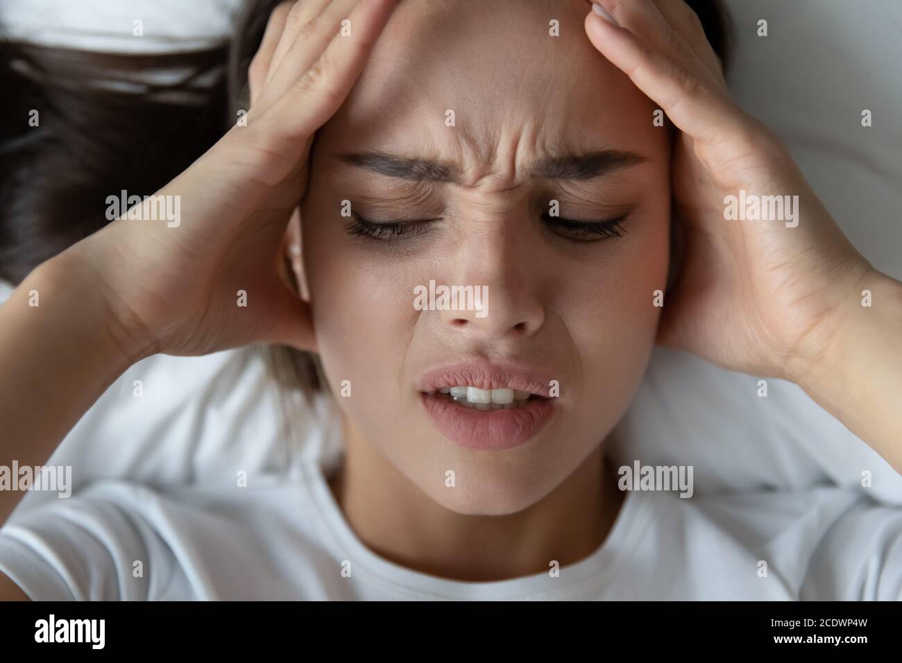 Vista dall'alto primo piano su una giovane donna esausta che tocca i templi Foto Stock