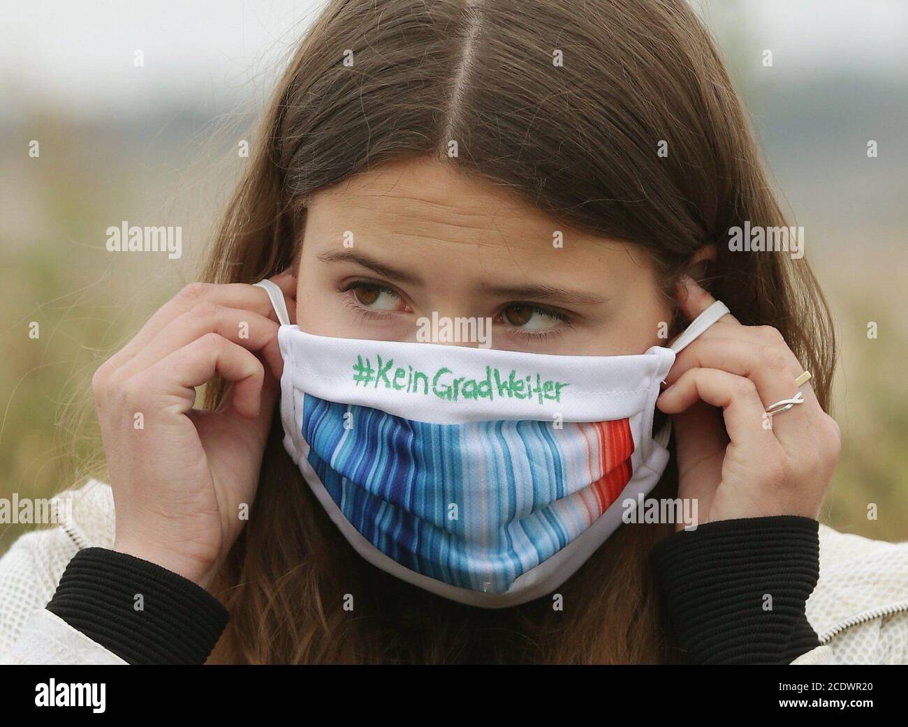 30 agosto 2020, Renania Settentrionale-Vestfalia, Jüchen: L'attivista ambientale Luisa Neubauer mette sulla sua maschera di fronte alla miniera a cielo aperto di Garzweiler con l'iscrizione "Kein Grad Weiter". Un'alleanza nazionale di associazioni ambientali e gruppi climatici vuole protestare contro la distruzione dei villaggi in pericolo e per la giustizia climatica. (Ripetizione con dettagli immagine modificati) Foto: David Young/dpa Foto Stock