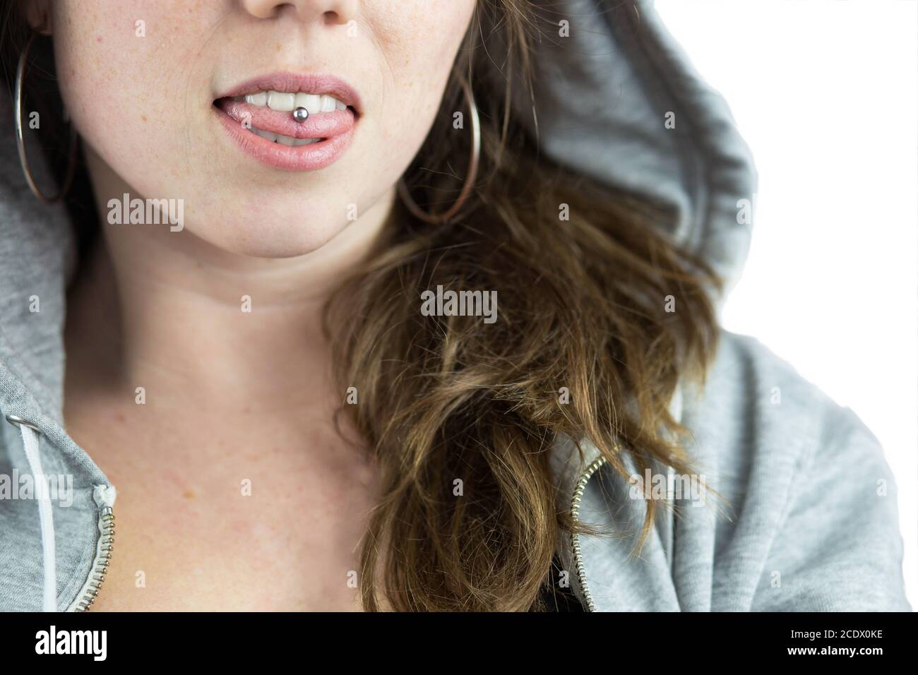 Young Teen ragazza con linguetta piercing e felpa con cappuccio Foto Stock